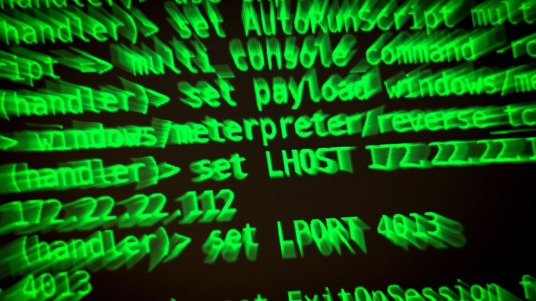Buchstaben und Zahlen leuchten auf einem Bildschirm, auf dem ein Hacker-Programm geöffnet ist. 