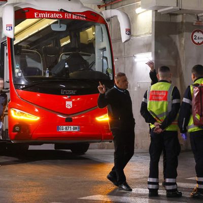 Feuerwehrleute stehen neben dem Mannschaftsbus von Olympique Lyon.