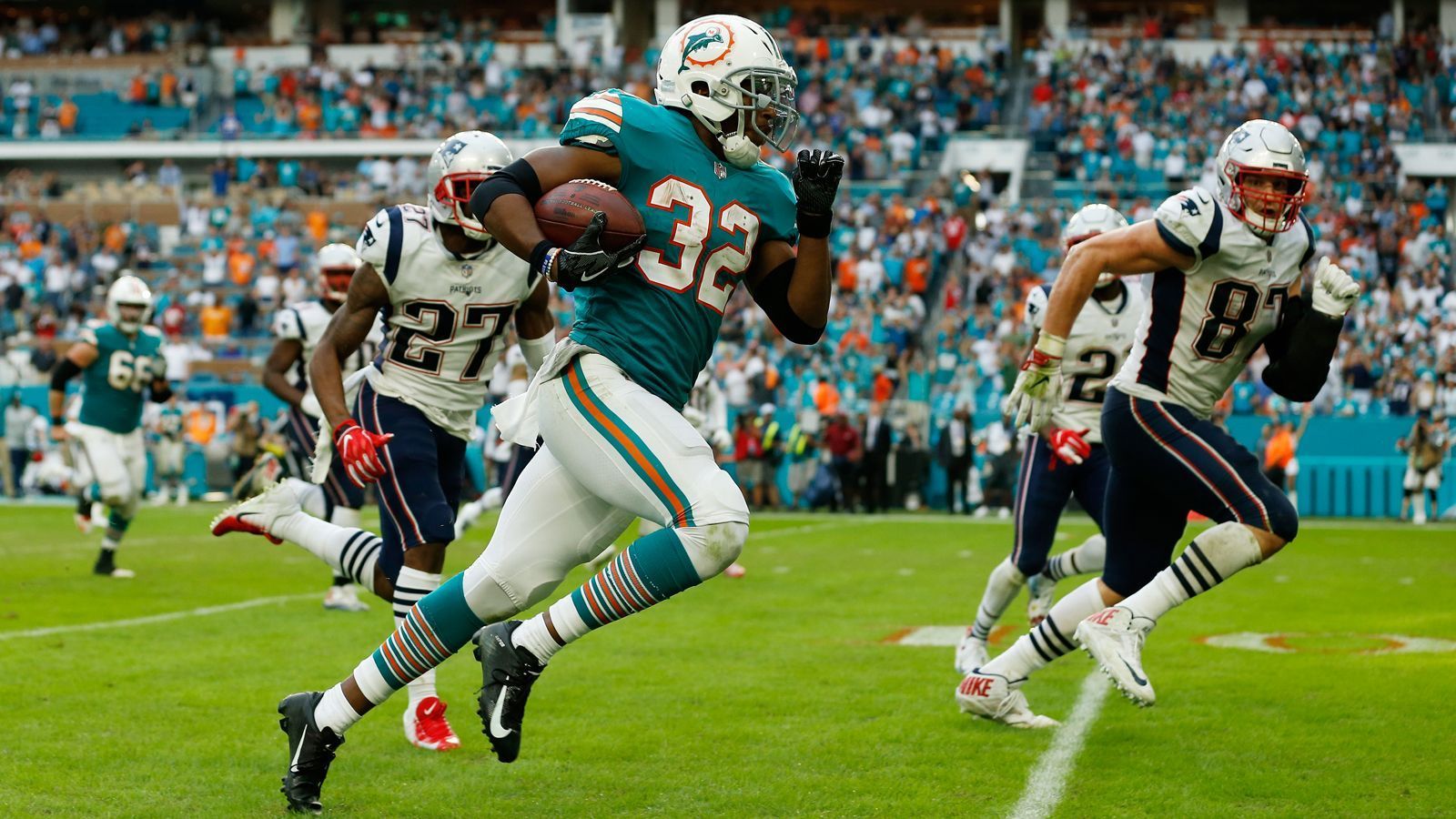 
                <strong>Week 14: Längster Walk-Off Touchdown der Super-Bowl-Ära</strong><br>
                Was für ein Finish zwischen den Miami Dolphins und den New England Patriots! Mit einem Touchdown beim letzten Spielzug der Partie bescherte Kenyan Drake (#32) den Miami Dolphins den Sieg. Ryan Tannehill fand Kenny Stills mit einem Pass über 14 Yards, der passte den Ball horizontal auf DeVante Parker. Er gab den Ball nach drei Yards weiter auf Drake, der die restlichen 52 Yards in die Endzone lief. Patriots-Star Rob Gronkowski (#87) sah dabei ziemlich schlecht aus und verpasste das entscheidende Tackle vor der Endzone. Mit 69 zurückgelegten Yards war es der längste Walk-Off-Touchdown - d.h. ein Touchdown mit der letzten Aktion des Spiels - der Super Bowl-Ära. "Es waren am Ende noch ich und Gronk und ich durfte mich nicht tacklen lassen. Sorry Gronk! Er ist ein toller Spieler, aber ich musste noch wohin", so Drake über das "Miami Miracle", wie mehrere US-amerikanische Medien den Spielzug betiteln.     
              