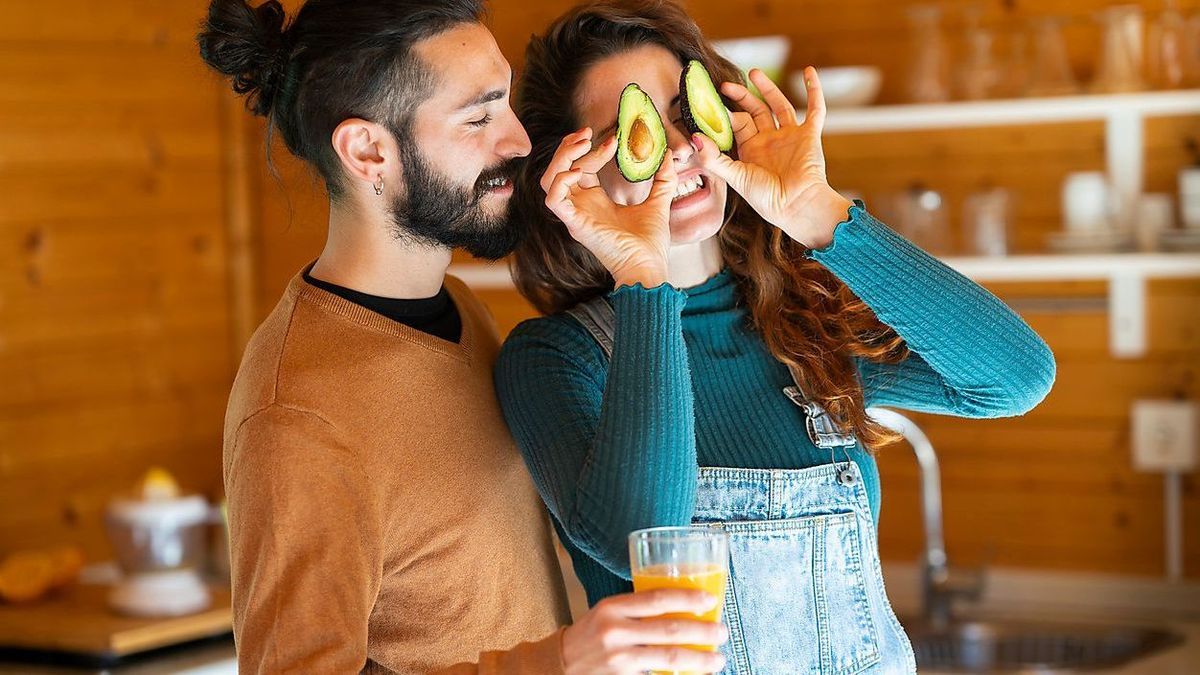 VSMF00089 - Playful young couple having fun with avocados in a wooden cabin