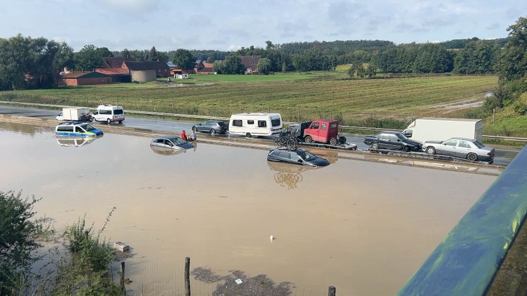 Fahrzeuge stehen auf der nach einem Unwetter auf der überfluteten Fahrbahn der Autobahn 2. 