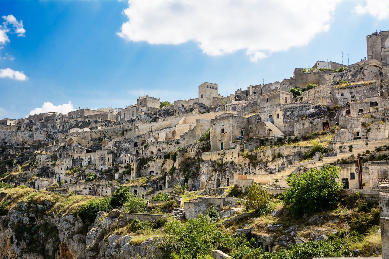 Die Wohnhöhlen von Sassi di Matera im Süden Italiens gibt es seit der Steinzeit. Seit 1993 zählen sie zum UNESCO-Weltkulturerbe. Bis in die 1950er-Jahre wohnten hier noch Menschen, allerdings ohne Strom und Wasser, und die hygienischen Zustände waren schrecklich. Also beschloss die Regierung, die Bewohner:innen in neue Wohnanlagen umzusiedeln.