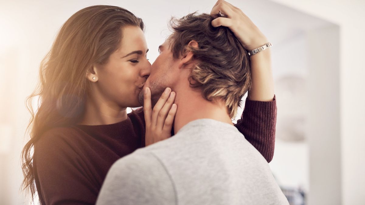 Face of happy woman, man and kiss with love in apartment for romance, intimacy and special moment together. Young couple kissing in home for romantic relationship, happiness and passionate partner