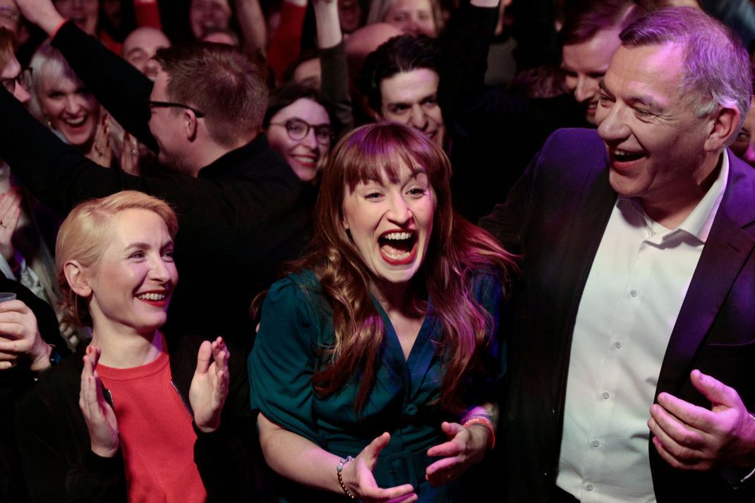 Heidi Reichinnek und Jan van Aken jubeln bei der Wahlparty der Partei Die Linke im Glashaus.