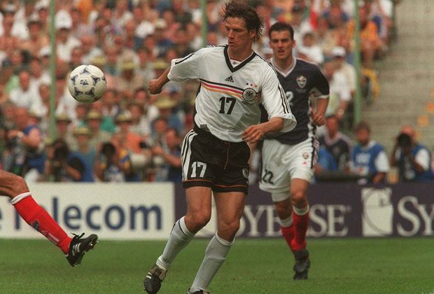 
                <strong>WM 1998</strong><br>
                In Frankreich versucht es die DFB-Auswahl mit V-Ausschnitt und drei Querstreifen in den Nationalfarben auf Brusthöhe. Doch für Christian Ziege und seine Teamkollegen endet das WM-Abenteuer erneut im Viertelfinale. Diesmal sind die Kroaten mehrere Nummern zu groß - das Spiel endet 0:3.
              