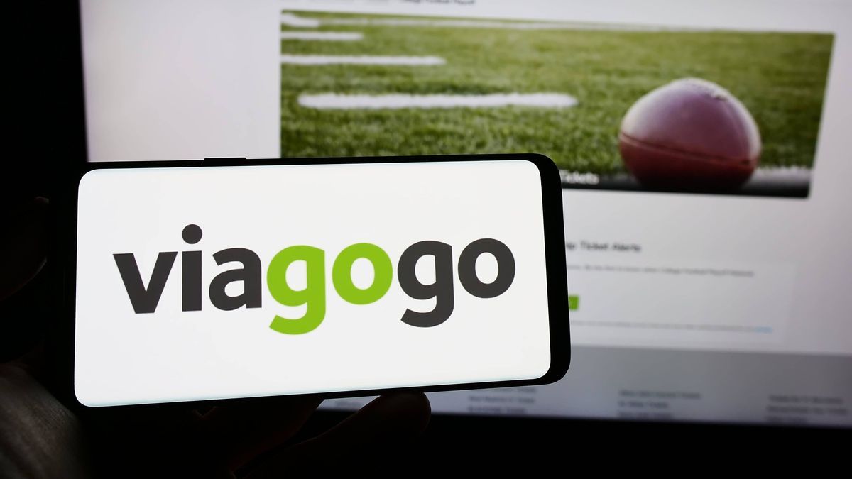 Person holding cellphone with logo of US ticket exchange platform company Viagogo on screen. Stuttgart, Germany - 01-14-2023: Person holding cellphone with logo of US ticket exchange platform compa...