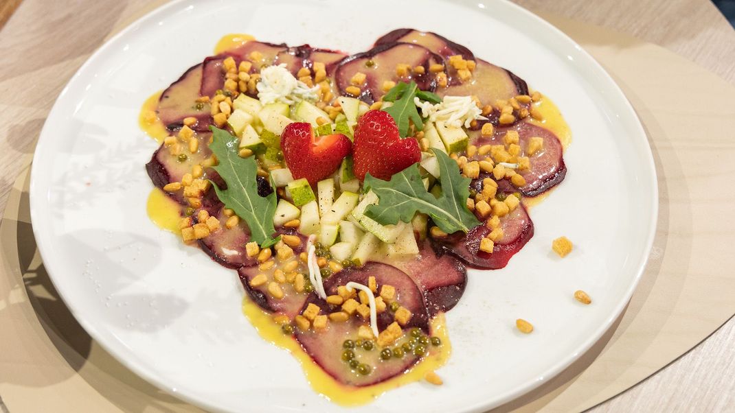 Herzförmiges Rote Bete Carpaccio mit Gorgonzola, Birnen, Pinienkernen und grüner Pfeffer Vinaigrette von Johann Lafer.