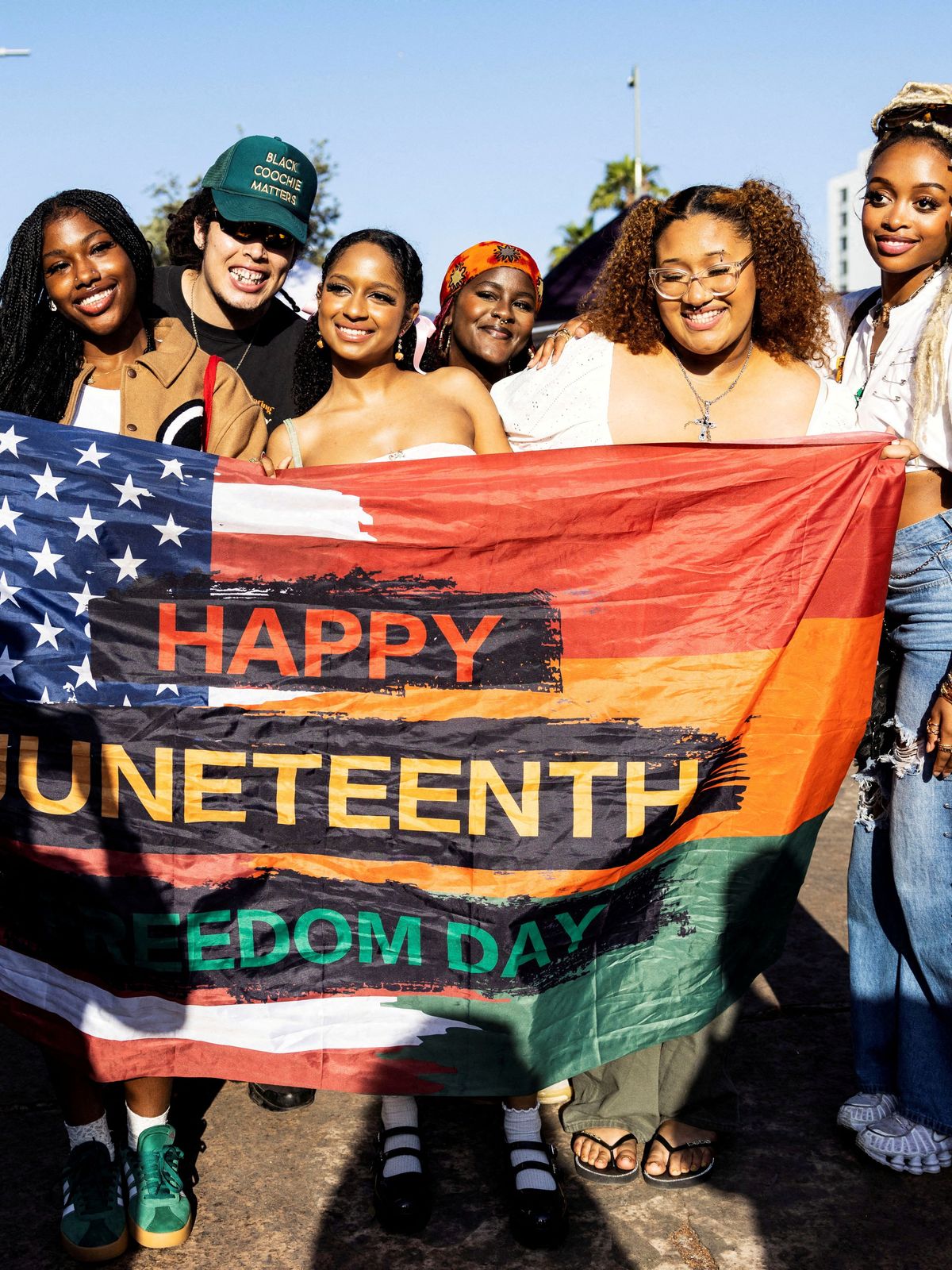 Menschen posieren für ein Foto während einer Veranstaltung zum Juneteenth 2024 im Leimert Park in Los Angeles, USA.