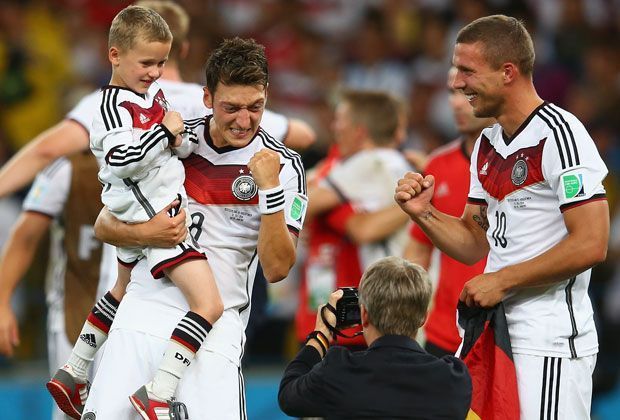 
                <strong>Mesut mit Podolski-Sohn Louis</strong><br>
                Und auch die Kleinsten dürfen mit auf den Rasen: Louis Podolski (l.) auf dem Arm von Mesut Özil.
              