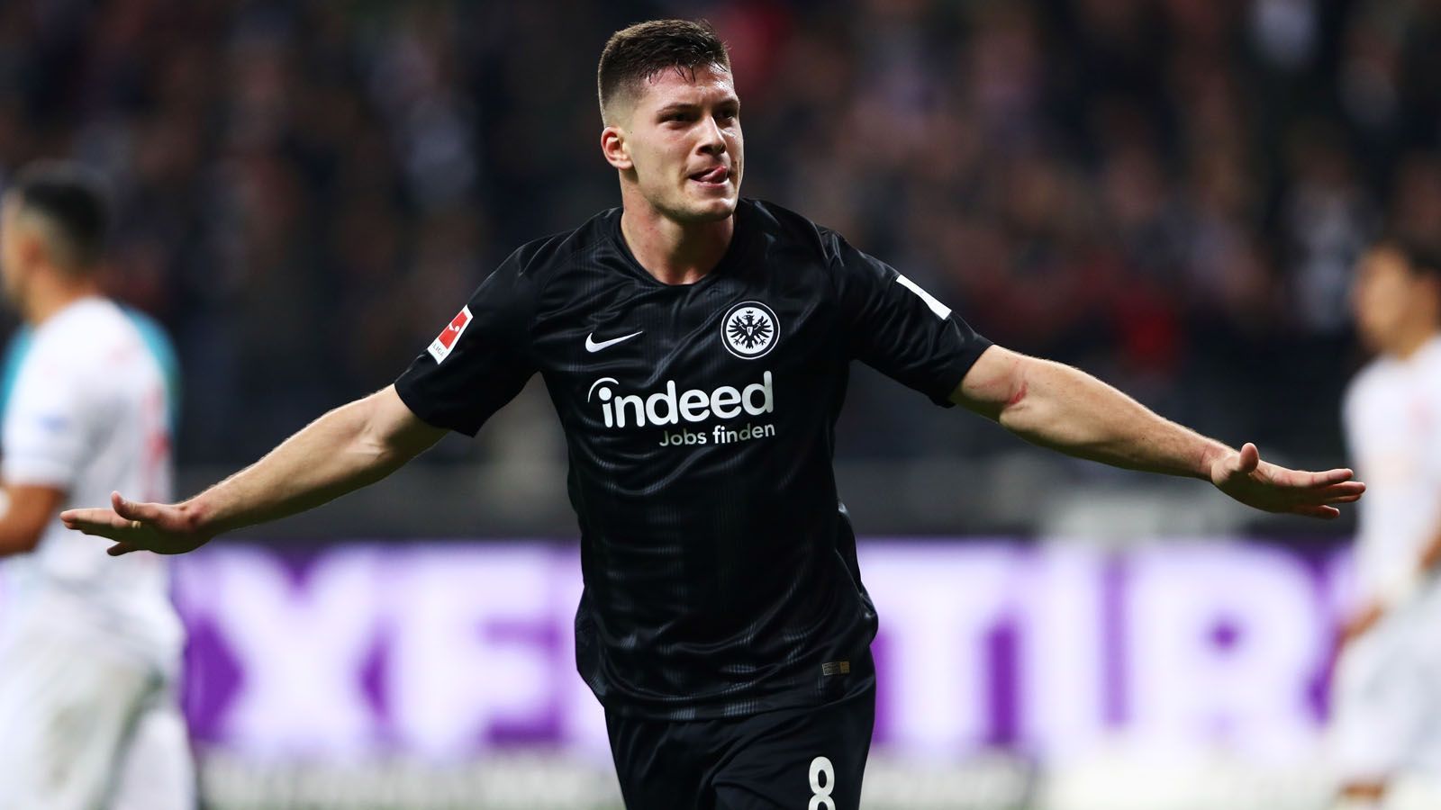 
                <strong>Mit der "Büffelherde" zum Topstar</strong><br>
                Die Fakten: Mit einer furiosen Saison 2018/19 und 27 Treffern spielte sich Jovic als Teil der "Büffelherde" mit Ante Rebic und Sebastien Haller auf den Radar der europäischen Topklubs. Vor allem sein Fünferpack gegen Fortuna Düsseldorf ist unvergessen. Im Sommer 2019 sicherte sich schließlich Real Madrid für 60 Millionen Euro Ablöse die Dienste des Serben. Jovic unterschrieb einen Vertrag bis 2025.
              