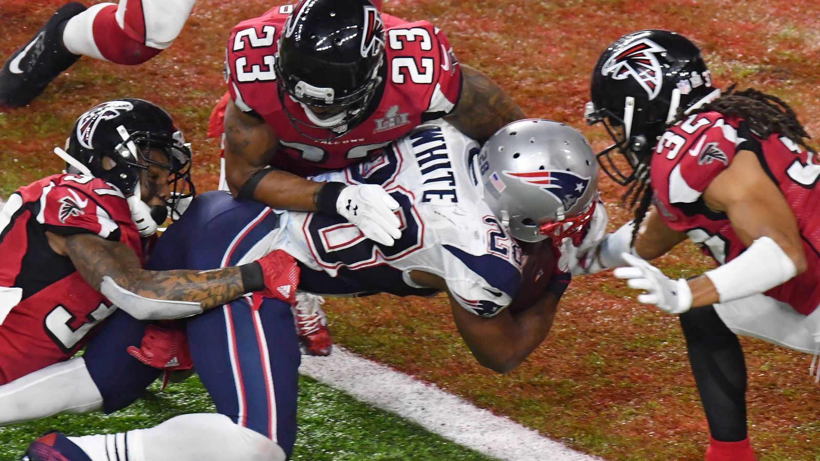 
                <strong>Geteilter Platz 7: New England Patriots (Super Bowl LI)</strong><br>
                Vielleicht das berühmteste Comeback der NFL-Geschichte. Im Super Bowl der Saison 2016 lagen die New England Patriots im dritten Viertel bereits mit 3:28 gegen die Atlanta Falcons hinten. Tom Brady sah alt aus, Bill Belichick erschien ratlos - die Dominanz der Patriots schien gebrochen. Doch dann drehte New England nochmal richtig auf: Im letzten Viertel gelangen ihnen sogar zwei Touchdowns plus 2-Point-Conversion - Ausgleich. In der Overtime kamen die Patriots mit ihrem ersten Drive in die Endzone und das Comeback war perfekt. 
              