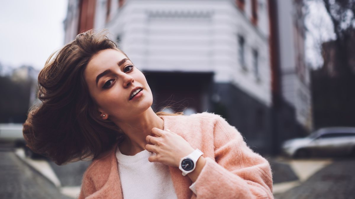 Young woman shaking hair on street