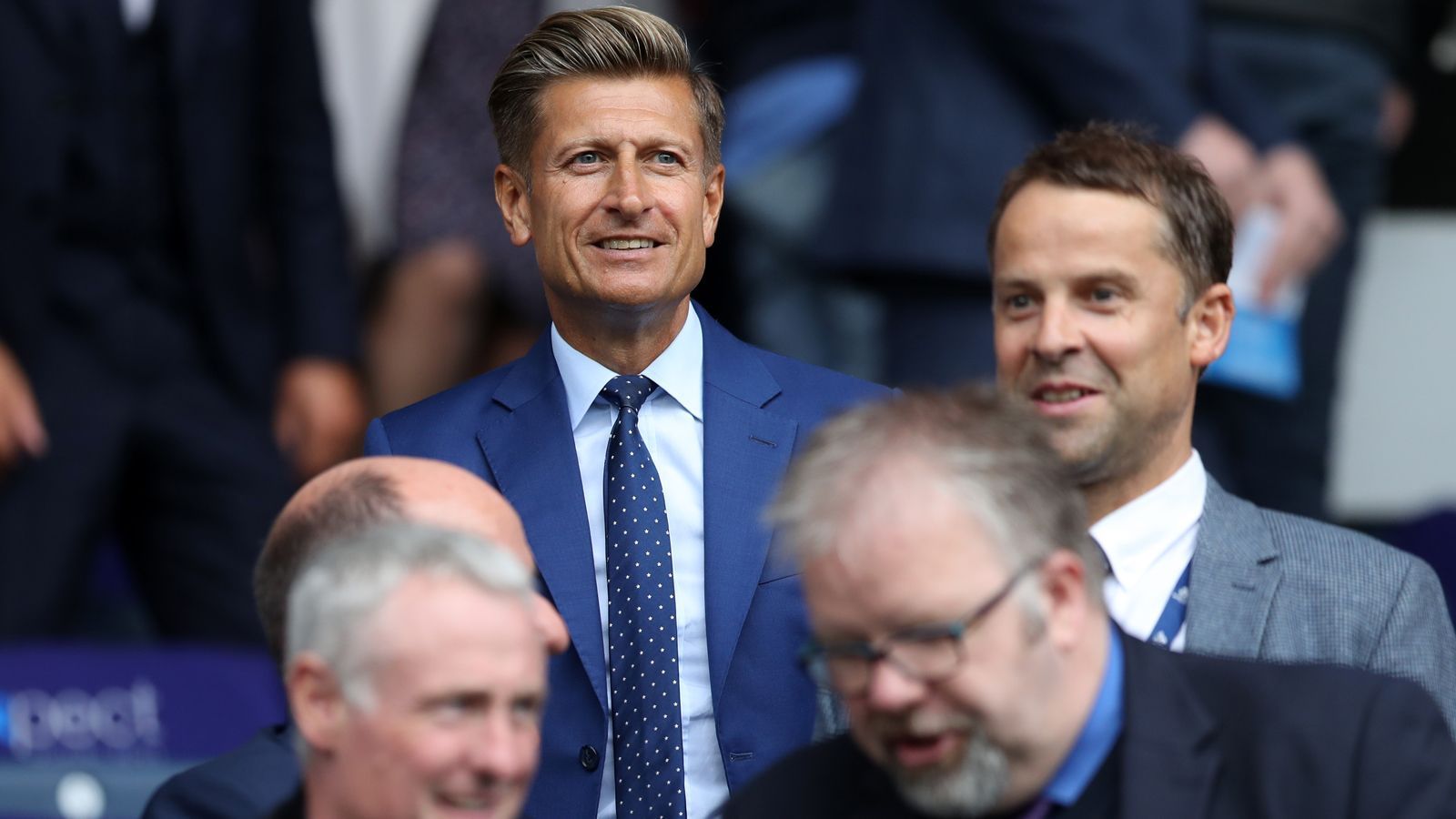 
                <strong>Crystal Palace: Steve Parish</strong><br>
                Steve Parish (li.) ist der Vorsitzende des Klubs aus London, er hält immer noch etwas über 10 Prozent der Anteile. Der Brite ist Palace-Fan und machte sein Vermögen mit der Firma "TAG Worldwide", die er 2010 verkaufte. Im gleichen Jahr half er Palace, die Insolvenz zu verhindern, indem er die finanziellen Probleme des Klubs persönlich beseitigte. 2015 stiegen seine Unternehmer-Kollegen David Blitzer und Joshua Harris mit je 18 Prozent der Anteile in den Klub ein. Der Mehrheitseigener seit dem August 2022 ist aber John Textor. Er soll laut "The Atheltic" 40 Prozent des Klubs besitzen.  
              