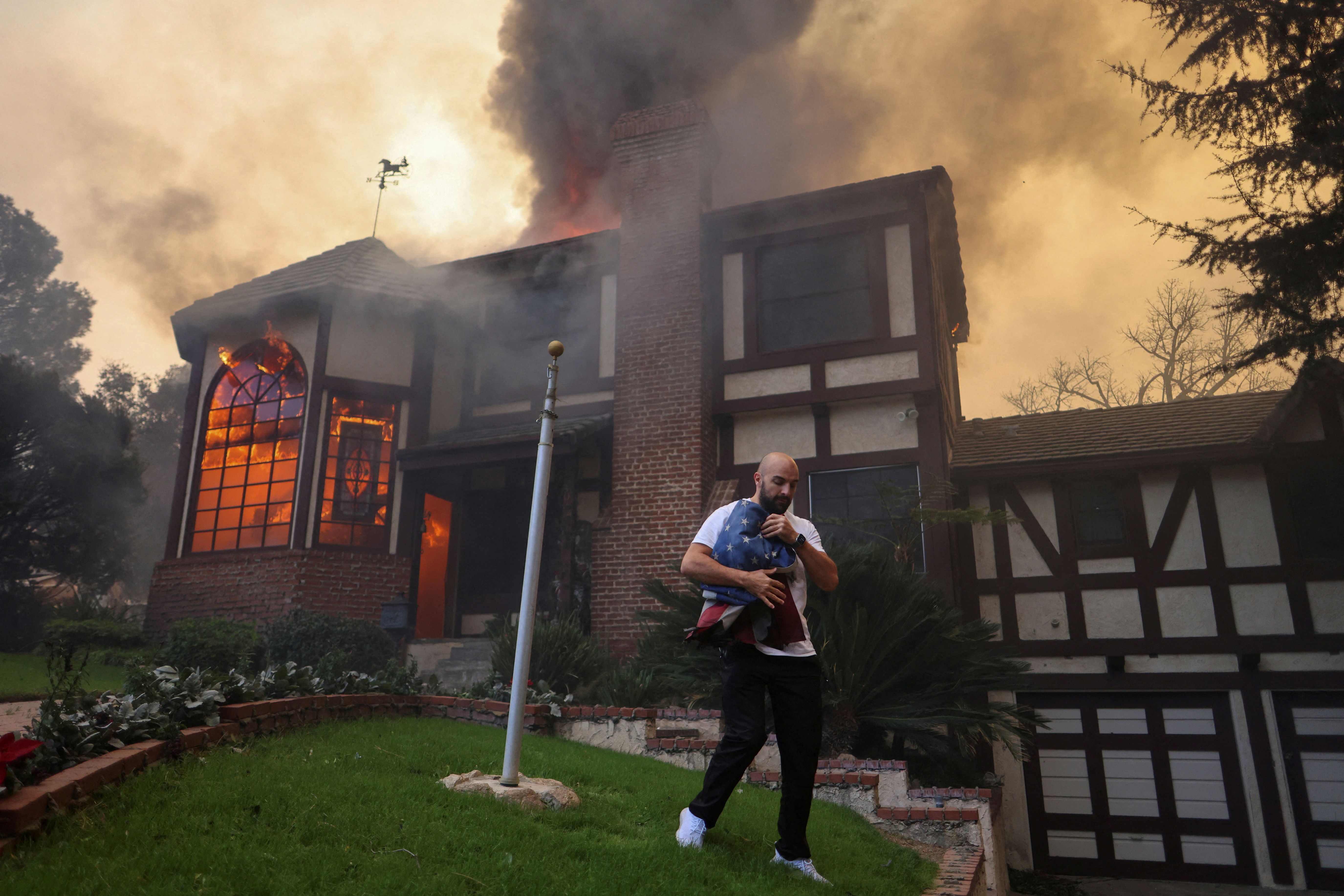 Eine Person rettet die amerikanische Flagge vor den Flammen.