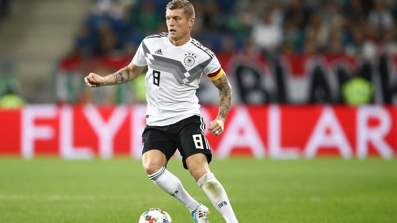 
                <strong>Zentrales Mittelfeld: Toni Kroos</strong><br>
                Seine Rolle ist flexibel. Toni Kroos könnte sowohl auf der Doppelsechs mit Emre Can spielen, als auch weiter vorne im zentralen Mittelfeld eine koordinierende Aufgabe übernehmen. Unter Löw ist er als Teil der "Weltmeister-Achse" gesetzt, bei Real Madrid in der Zentrale ebenfalls. In beiden Teams läuft es derzeit nicht. Doch auf Toni Kroos zu verzichten, wäre verheerend. Er ist als Ballverteiler und Leader im Mittelfeld unverzichtbar, gerade in einem Team mit vielen jungen Spielern. Zuletzt ließ er seine Gefährlichkeit bei Standards vermissen. Diese sollte er schnell zurückgewinnen, dann wäre wohl auch das ein oder andere Tor mehr im gegnerischen Kasten. 
              