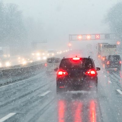 highway with cars in winter with snow fall