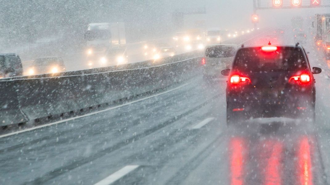 highway with cars in winter with snow fall