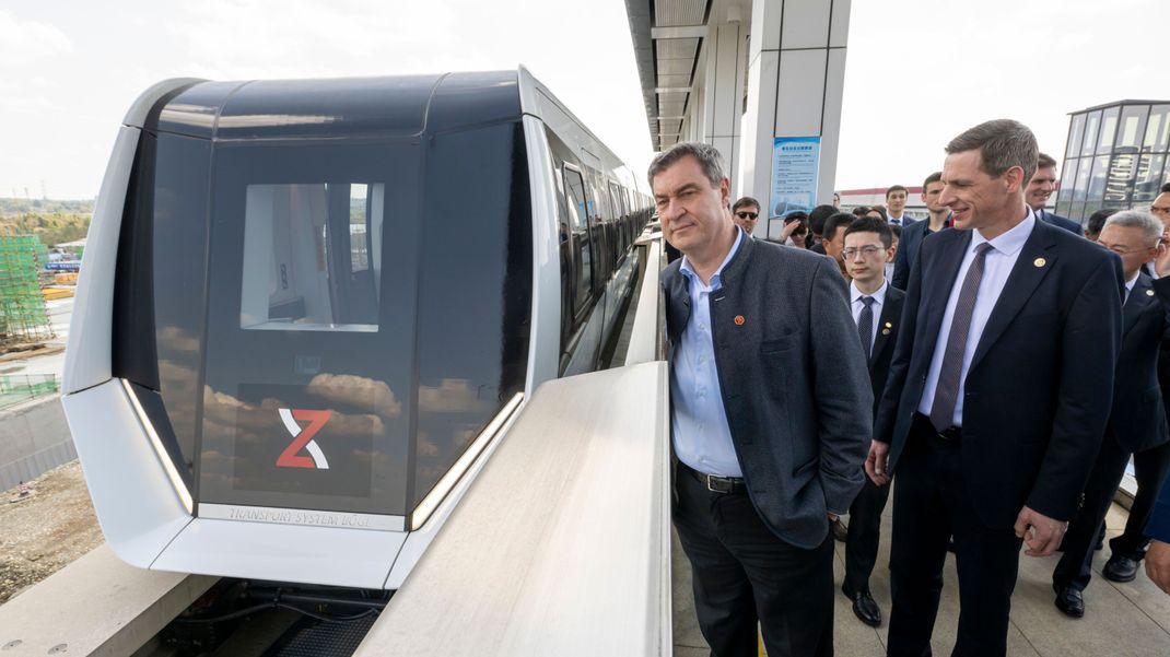 Markus Söder (l, CSU), Ministerpräsident von Bayern, besucht die Xinzhuluqiao Machinery Ltd. in Chengdu, um eine Fahrt mit der Magnetschwebebahn zu absolvieren.