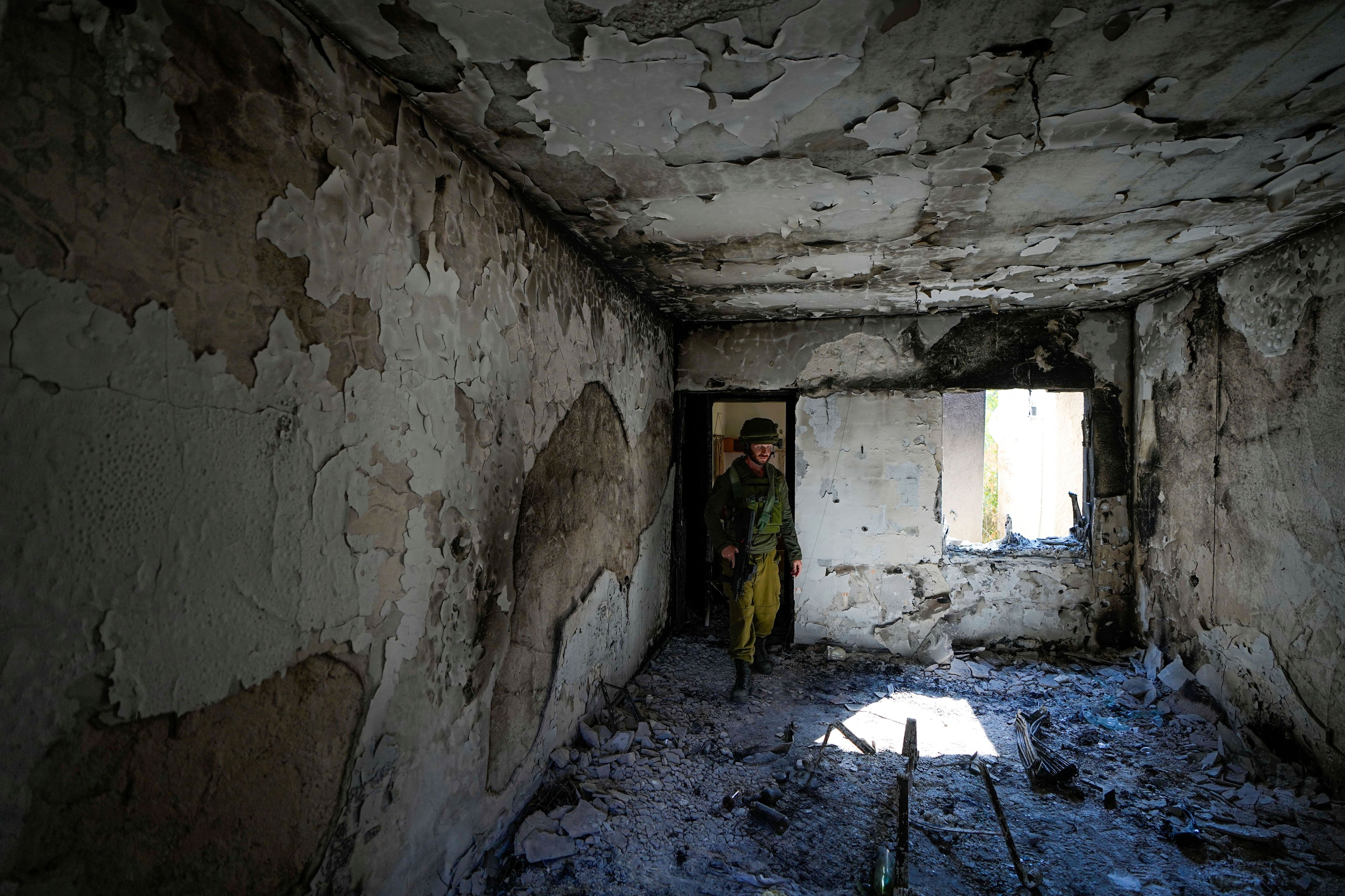 In Kfar Aza wurden die Bewohner:innen vom Hamas-Angriff überrascht. Hier inspiziert ein israelischer Soldat ein zerstörtes Wohnhaus.