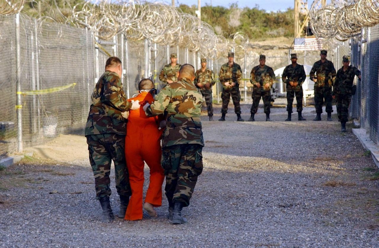 Ein Häftling wird im Camp X-Ray auf dem Marinestützpunkt Guantanamo Bay, Kuba, zu seiner Zelle eskortiert.
