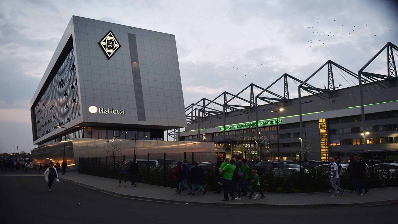 
                <strong>Borussia Mönchengladbach: Stadionhotel und riesige Erlebniswelt</strong><br>
                Der Borussia-Park hat sich in den letzten Jahren deutlich modernisiert. Zwar nicht in der Arena selbst, aber außen herum entstand ein neuer Komplex mit integriertem Hotel und einer 1.000 Quadratmeter großen Erlebnis-Welt im Gladbach-Style. Die Zimmer des Hotels mit über 100 Zimmern sind in Borussia-Farben gehalten, die meisten bieten einen einmaligen Blick auf die Arena.
              