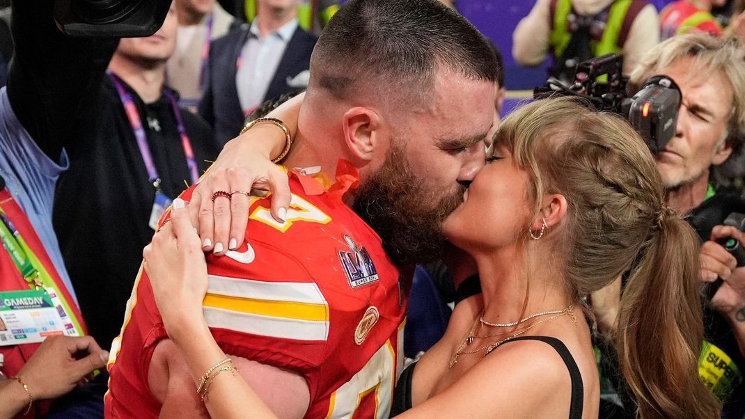 Travis Kelce und Taylor Swift knutschend nach einem Spiel der Kansas City Chierfs.