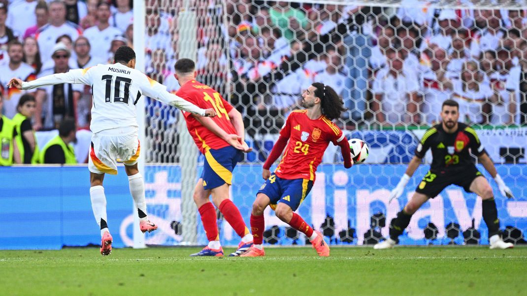 Deutschlands Jamal Musiala (l-r) in Aktion gegen Spaniens Aymeric Laporte, Marc Cucurella, der mit einem Handspiel abwehrt.