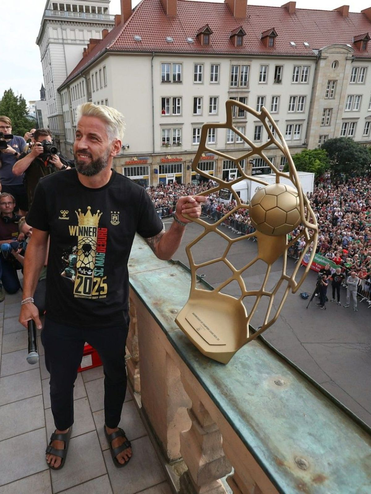Wiegert reckt beim Emfang den Pokal in die Höhe.