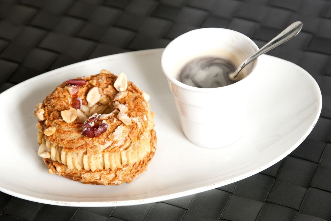 Diese Spezialität heißt Paris-Brest. Schräge Bezeichnung? Sie stammt von einem gleichnamigen Radrennen ab. Die Form des Kuchens aus Buttercreme, Praline und Blätterteig erinnert an einen Fahrradreifen.