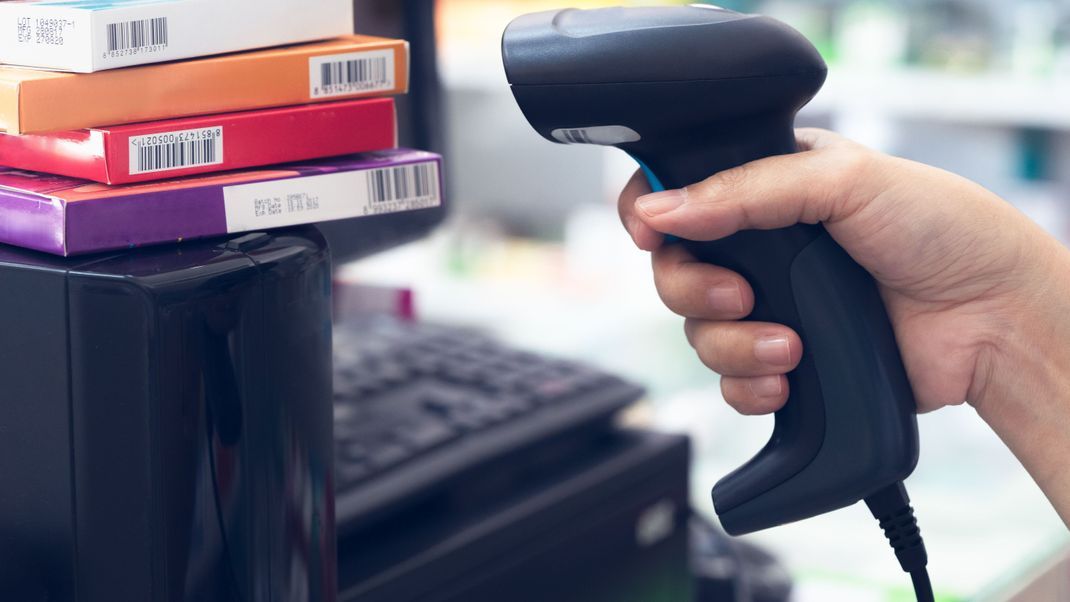 Pharmacist scanning barcode on medicine boxes