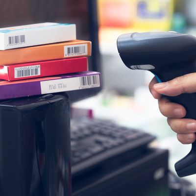 Pharmacist scanning barcode on medicine boxes