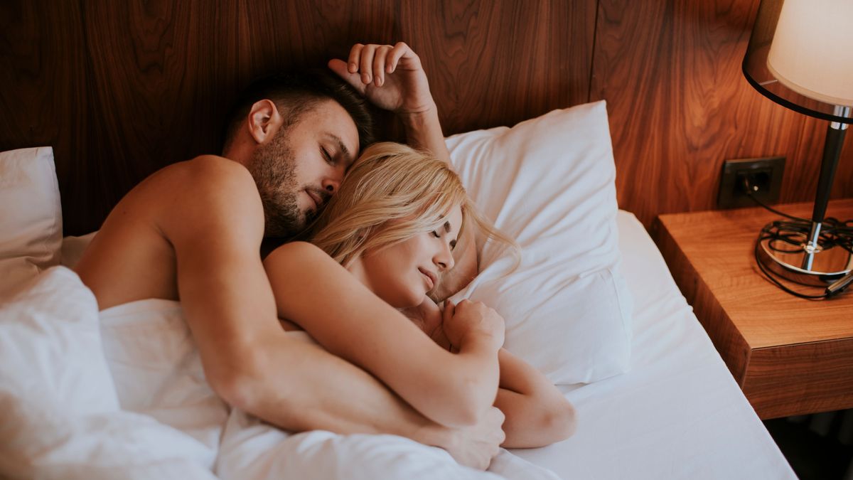 Lovely couple hugging on their bed at home