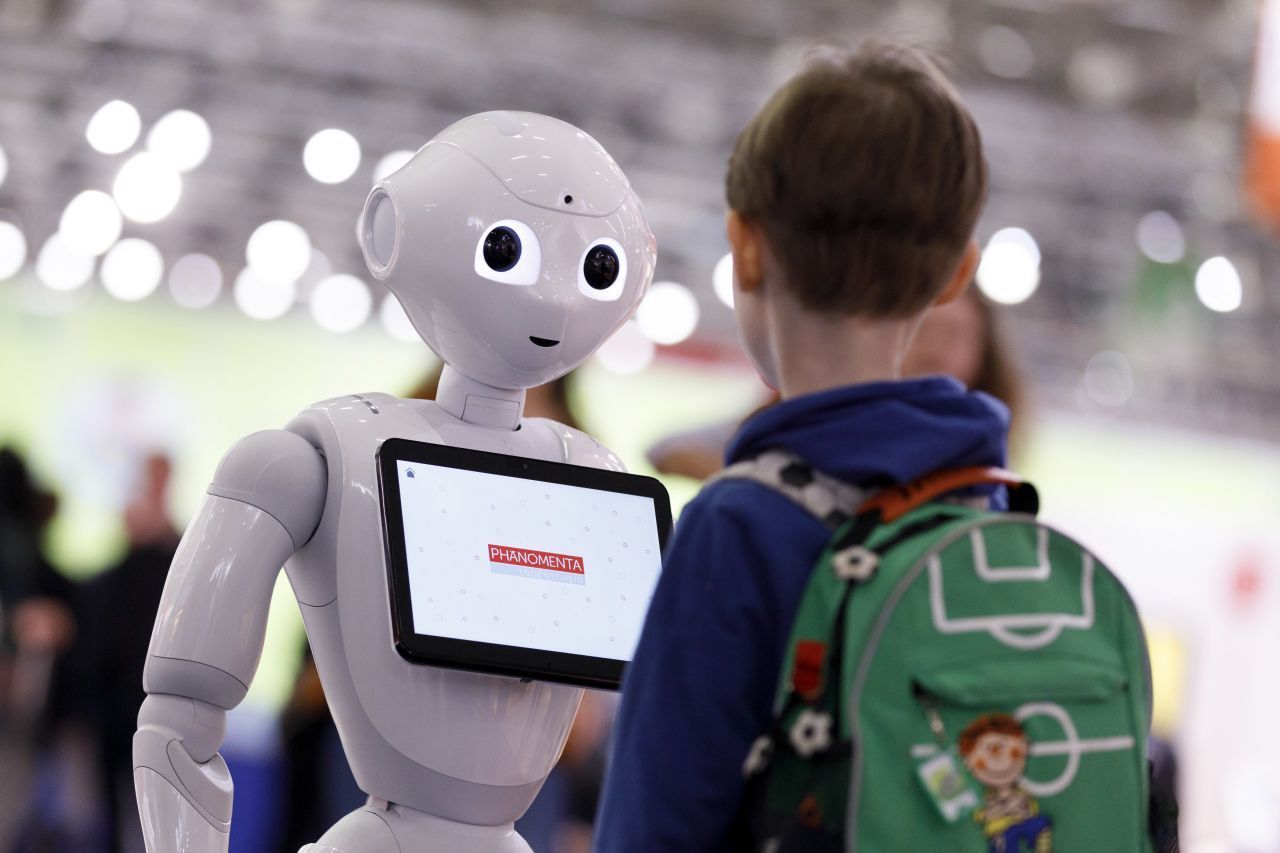 Der Roboter Pepper unterhält sich auf der Bildungsmesse in Köln mit einem Schulkind. In Japan berät Pepper zum Beispiel Kund:innen beim Kauf von Nespresso-Maschinen.