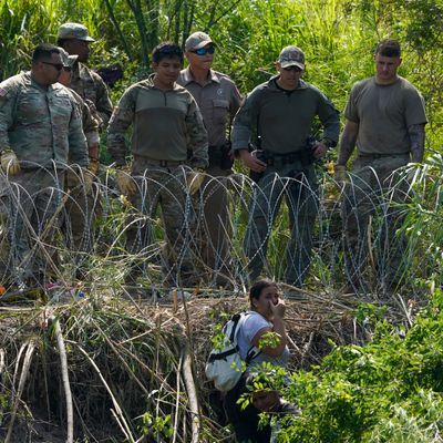 US-Polizisten beobachten eine Migrantin auf mexikanischer Seite.