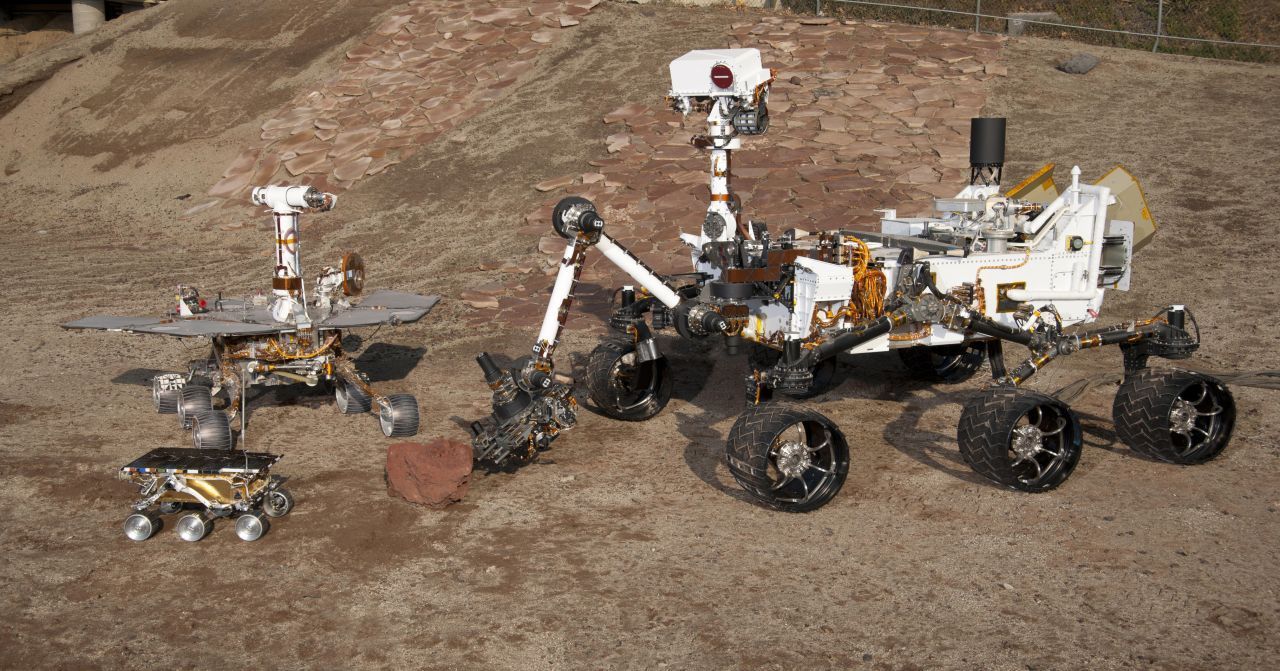 Gruppenbild mit Rover: Zusammengestellt lässt sich gut erkennen, wie die Mars-Rover der NASA über die drei Generationen hinweg immer größer geworden sind: Links unten "Sojourner", links oben "Spirit" (und "Opportunity") und rechts "Curiosity" (und "Perseverance").