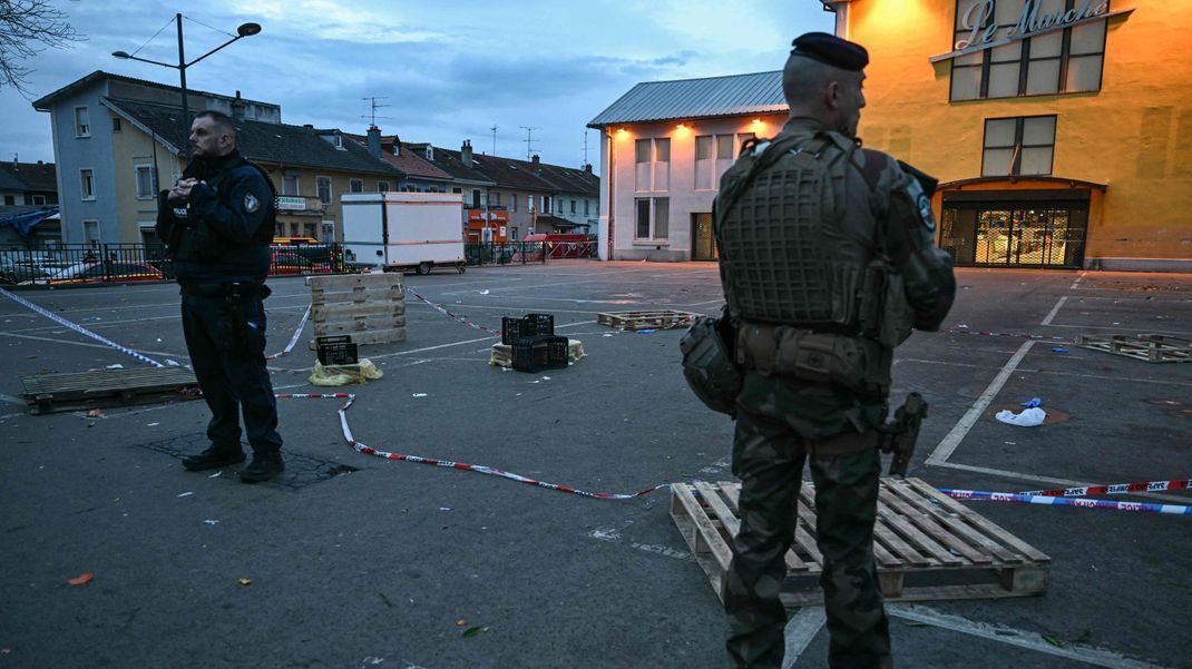 22. Februar 2025, Frankreich, Mulhouse: Ein Polizist und ein Soldat stehen am Ort eines Messerangriffs. Nach einem Angriff im elsässischen Mulhouse mit einem Toten und mehreren Verletzten hat die französische Anti-Terror-Staatsanwaltschaft die Ermittlungen übernommen. 