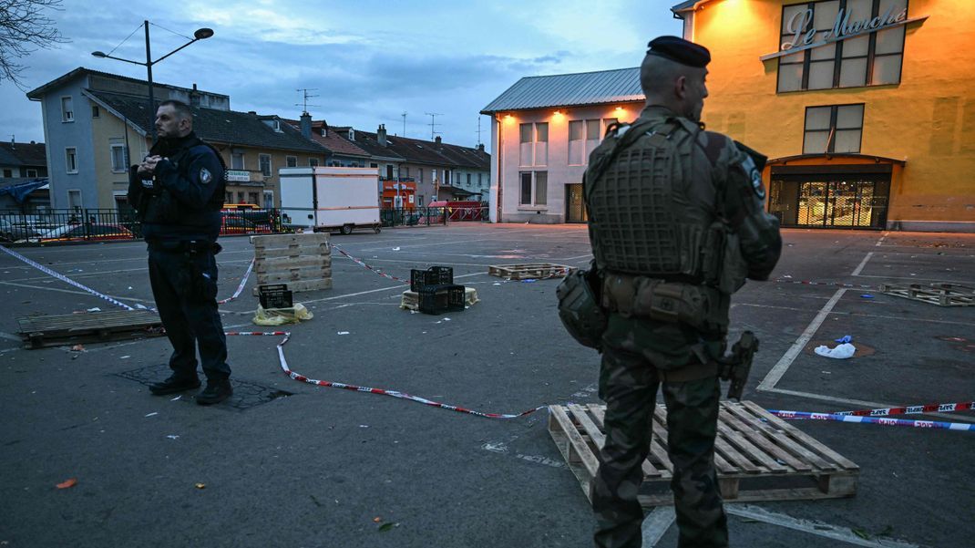 22. Februar 2025, Frankreich, Mulhouse: Ein Polizist und ein Soldat stehen am Ort eines Messerangriffs. 