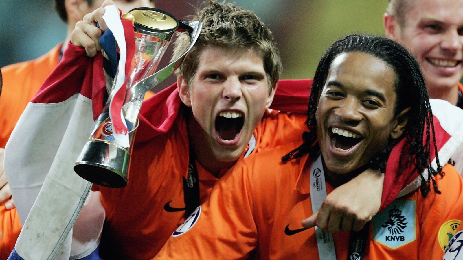 
                <strong>2006 - Klaas-Jan Huntelaar (Niederlande)</strong><br>
                Mit der U21-EM-Endrunde 2006 begann die kurze niederländische Dominanz bei diesem Turnier. In Portugal schoss Klaas-Jan Huntelaar (l.) die "Elftal" zum Titel. Alleine im Endspiel gegen die Ukraine (3:0) traf der "Hunter" zweimal, insgesamt bei der Endrunde viermal und wurde so Torschützenkönig und bester Spieler des Turniers. Damals stand er noch bei Ajax Amsterdam unter Vertrag, wohin er im Sommer 2017 zurückkehrte. Zwischenzeitlich hatte Huntelaar neben Schalke sehr prominente Stationen wie Real Madrid oder den AC Milan. Aktuell fristet der 37-Jährige ein Reservisten-Dasein bei Bundesliga-Schlusslicht Schalke. Zu den Gelsenkirchenern kehrte der Oldie Anfang 2021 zurück, um S04 mit Toren in der Bundesliga zu halten. Daraus wurde bislang nichts und so dürfte der "Hunter" seine Karriere im Sommer 2021 als Absteiger beenden. 
              