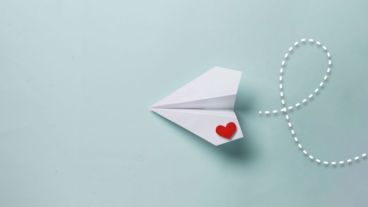 paper love airplane on color background..The concept of a love message. Valentine's Day. Declare love. Love note.