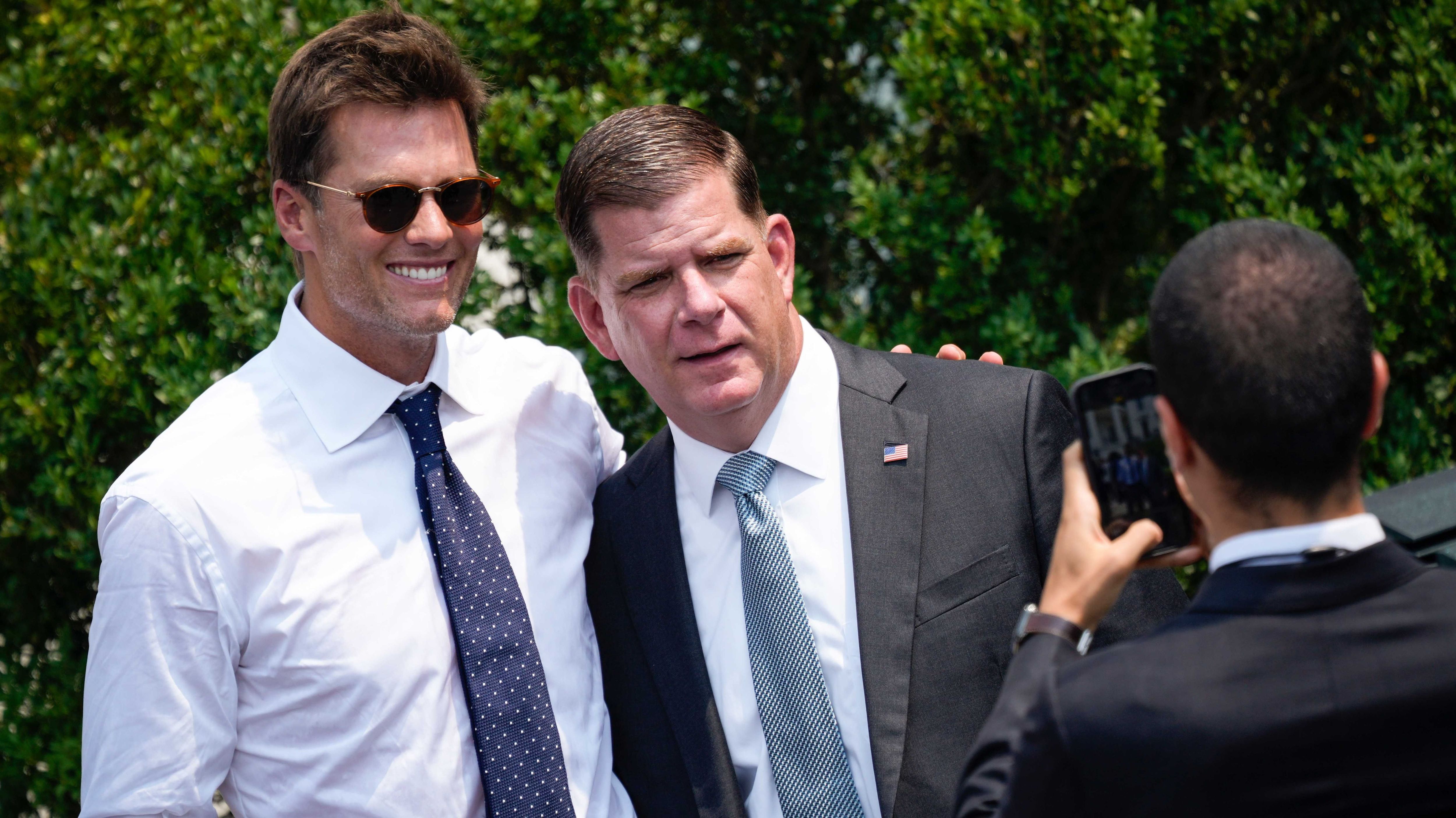 
                <strong>Alle wollen Fotos mit Tom</strong><br>
                Kaum zu Glauben: Für Brady war es der erste Besuch im Weißen Haus seit 2005. 2015 und 2017 verzichtete er, 2019 entschied sich die gesamte Franchise der New England Patriots für einen Boykott. Kein Wunder, dass auch einige Abgeordnete ein Foto mit dem G.O.A.T. wollten. Hier: Marty Walsh. 
              