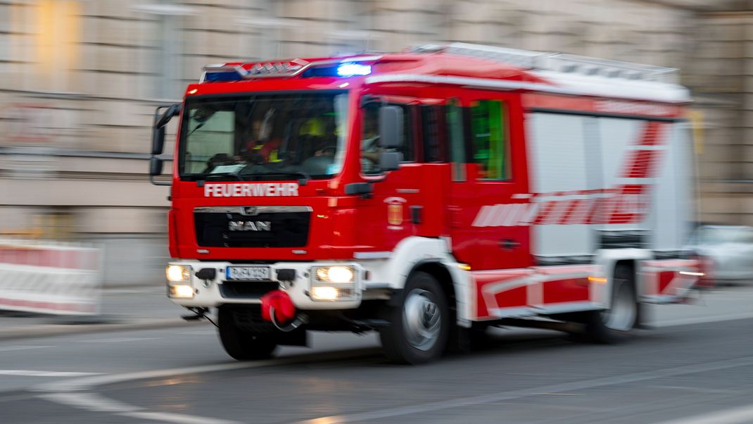 Ein Feuerwehrauto mit eingeschaltetem Blaulicht fährt zum Einsatz