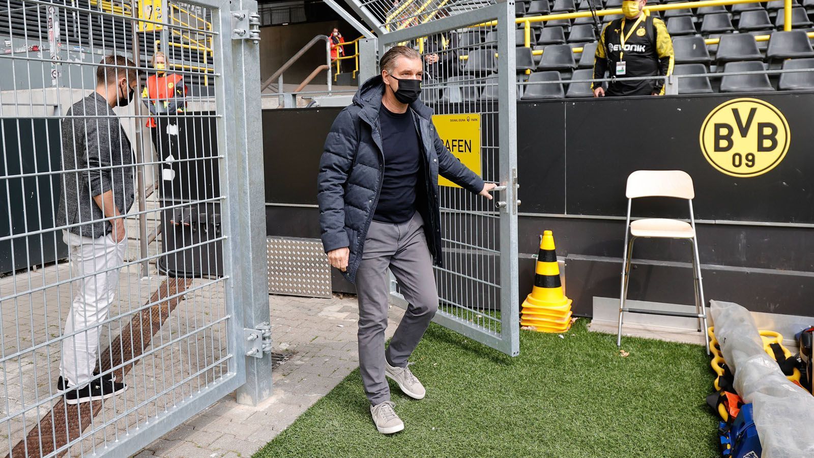 
                <strong>Die kuriosen Bilder des Bundesliga-Restarts</strong><br>
                Ein Weg, den es so wohl auch nur bei Geisterspielen gibt. BVB-Sportdirektor Michael Zorc betritt vor dem Spiel den Rasen.
              