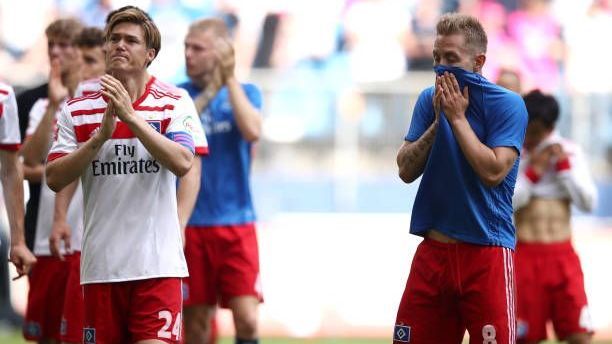 <strong>Hamburger SV: Eine Chronik des Leidens und Scheiterns</strong><br>Im Mai 2018 war es besiegelt: Zum ersten Mal in der Vereinsgeschichte musste der Hamburger Sportverein den Weg in die 2. Bundesliga antreten. Die Hoffnung auf eine schnelle Rückkehr war groß. Mehrmals scheiterten die Rothosen jedoch tragisch am Wiederaufstieg. <strong><em>ran</em></strong> zeigt die tragischsten Momente der Hamburger im deutschen Unterhaus.