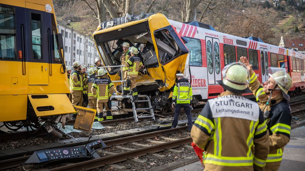 Einsatzkräfte der Feuerwehr arbeiten an den zwei zerstörten Stadtbahnen.