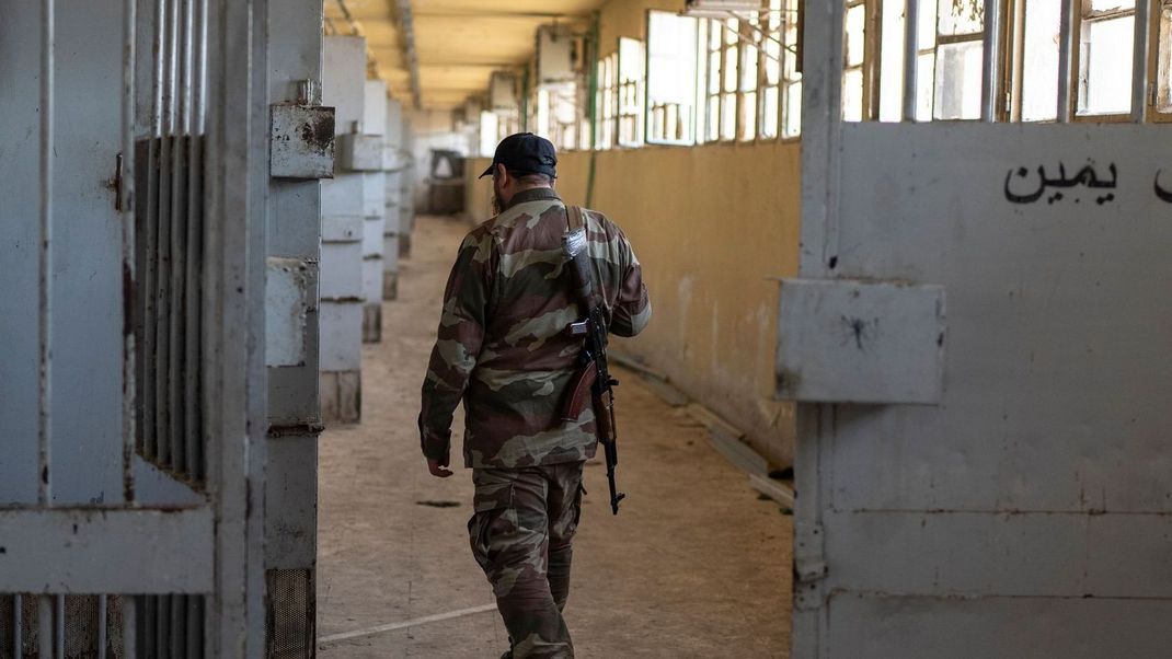 Ein Mitglied der neuen syrischen Sicherheitskräfte geht die Zellengalerie des Militärgefängnisses Saidnaja am Stadtrand von Damaskus entlang.
