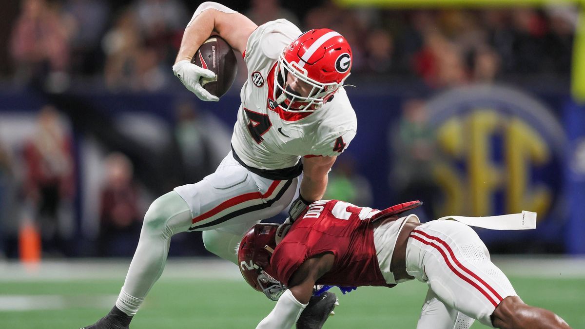 December 3, 2023, Atlanta, GA, USA: Georgia tight end Oscar Delp (4) is stopped by Alabama defensive back Caleb Downs (2) during the first half of the SEC Championship game at Mercedes-Benz Stadium...