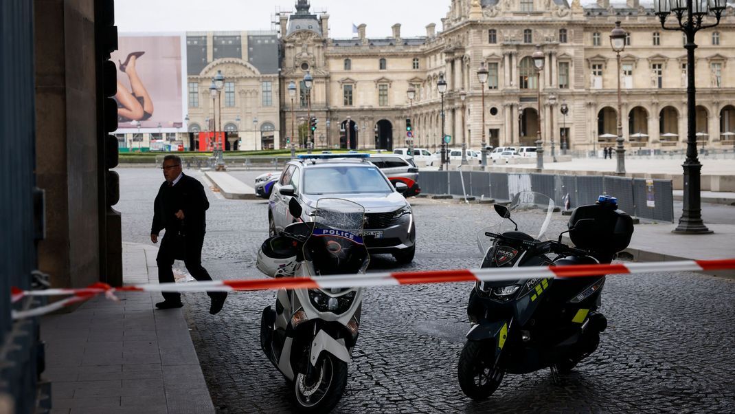 Polizeibeamte stehen vor dem Louvre Wache, der wegen einer Bombendrohung geräumt worden ist.