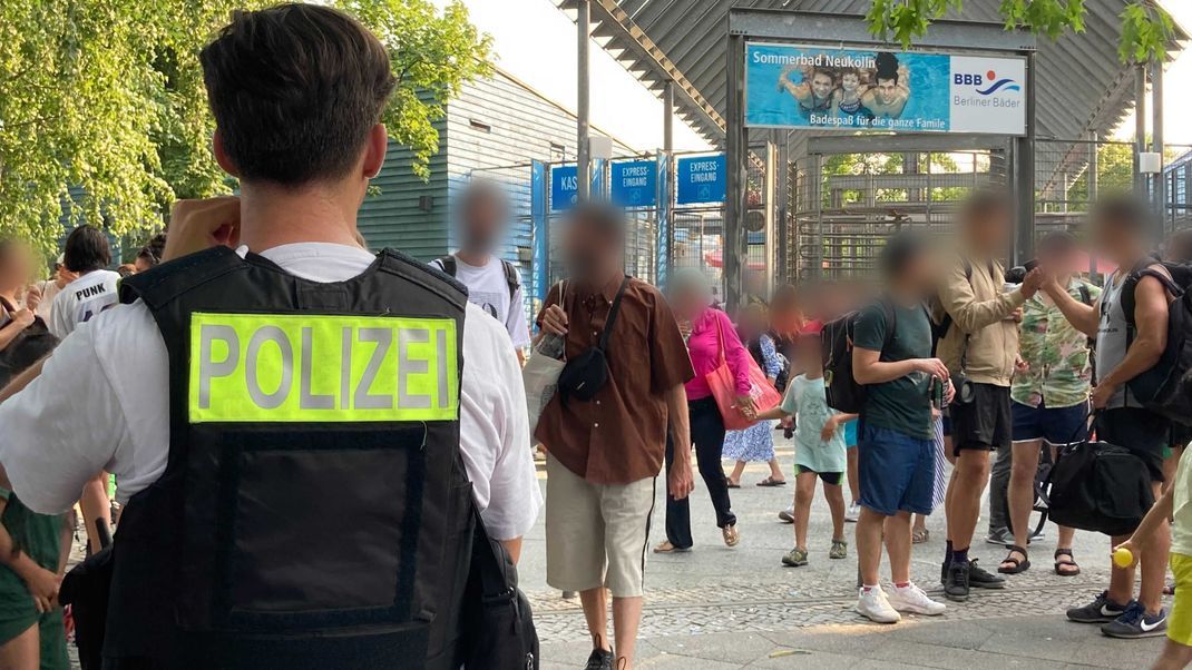 09.07.2023, Berlin: Polizisten stehen vor dem Eingang des Sommerbad in Neukölln. Das Berliner Freibad wird wegen seiner Lage am Columbiadamm auch Columbiabad genannt.
