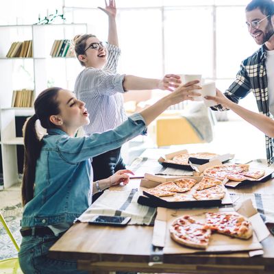 Enthusiastic mates raising toast while having party in flat