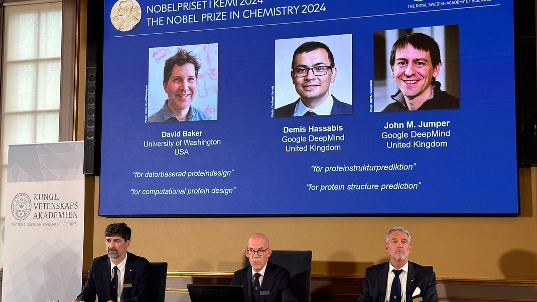 Auf der Leinwand während der Pressekonferenz zur Bekanntgabe des Chemie-Nobelpreises 2024 werden Bilder von David Baker (l-r), Demis Hassabis, und John M. Jumper gezeigt.